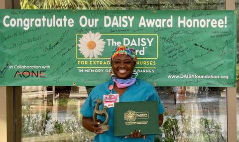 Image of Honoree in front of DAISY banner